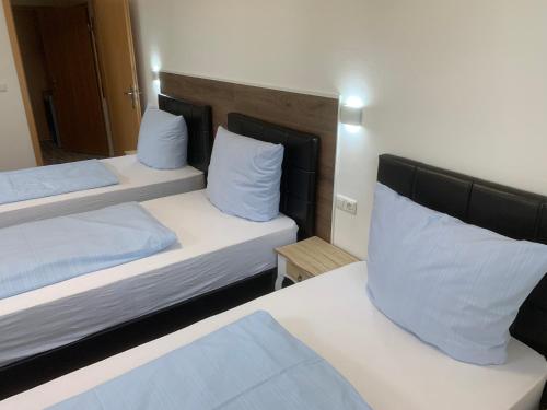 two beds in a hotel room with white pillows at Gasthof Löwen in Pfronten