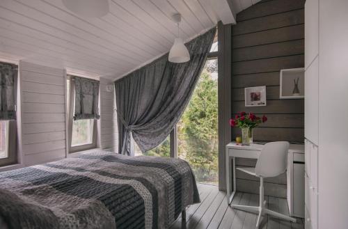 a bedroom with a bed and a desk and a window at Talitsy Lodge in Talitsa