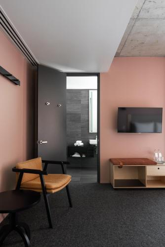 a living room with a chair and a table at Alex Hotel in Perth