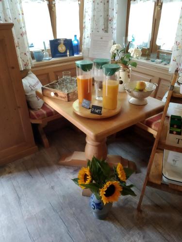 a table with three glasses of orange juice on it at Frühstückspension Helmhof in Salzburg