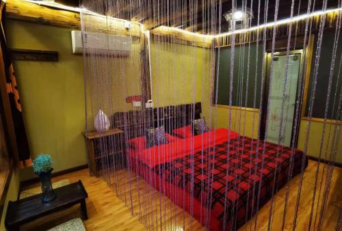 a bedroom with a red bed in a room at Shangri-La King Gesar Guesthouse in Shangri-La