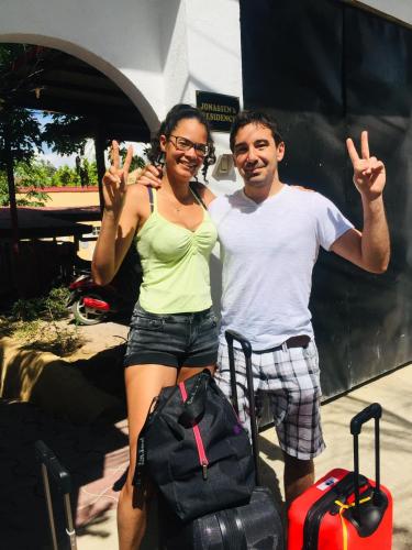a man and a woman standing next to luggage at Little Norway Guesthouse - Mactan Cebu International Airport in Mactan