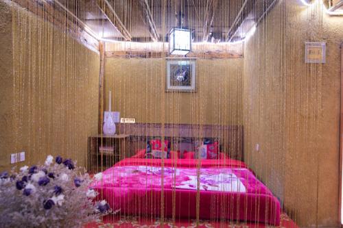 a bedroom with a pink bed in a room at Shangri-La King Gesar Guesthouse in Shangri-La