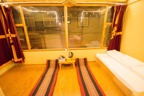 a room with a bed and a window and a table at Shangri-La King Gesar Guesthouse in Shangri-La