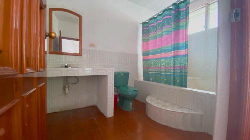 y baño con aseo, lavabo y espejo. en Hotel Posada Don Carlos, en Panajachel