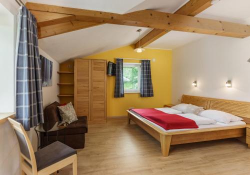 ein Schlafzimmer mit einem großen Bett und einem Stuhl in der Unterkunft Appartements Naturnah in Schladming