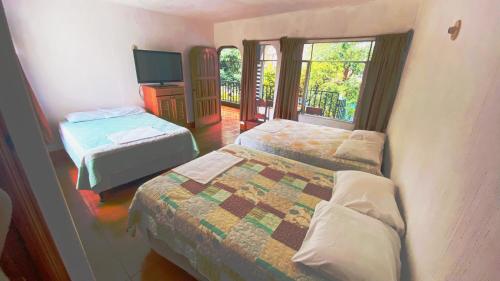 a hotel room with two beds and a television at Hotel Posada Don Carlos in Panajachel