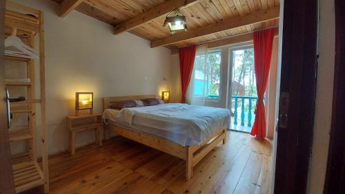 ein Schlafzimmer mit einem Bett und einem großen Fenster in der Unterkunft Villa Villekulla in Grigoleti