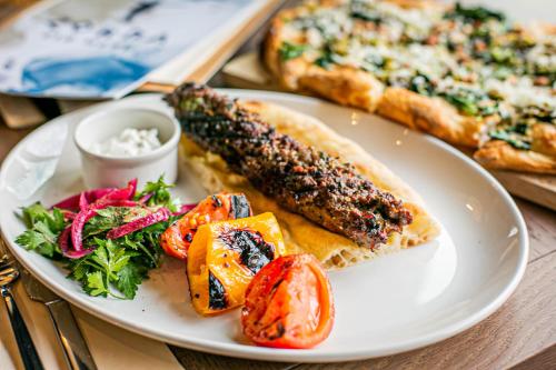 a plate of food with pizza and vegetables on a table at Hotel Marina Club Old Town View in Gdańsk
