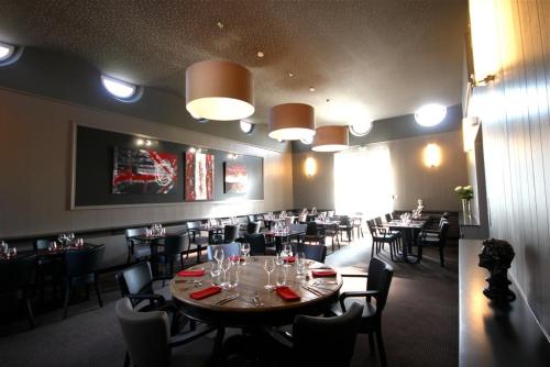 a dining room with a large table and chairs at Hôtel la Régie in Briey