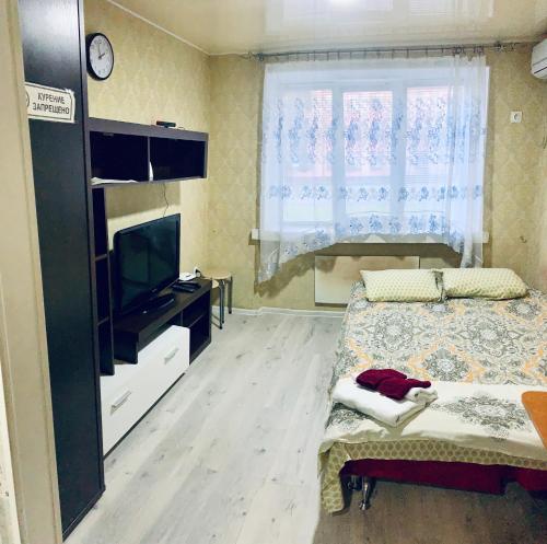 a bedroom with a bed and a tv and a window at Сomfort24 Апартаменти на проспекті Гагаріна Мечнікова Apartment on Gagarina in Dnipro