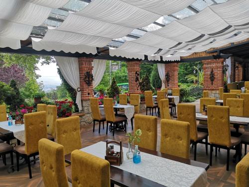 un restaurante con mesas y sillas y un gran techo en Hotel Sumski Feneri en Bitola