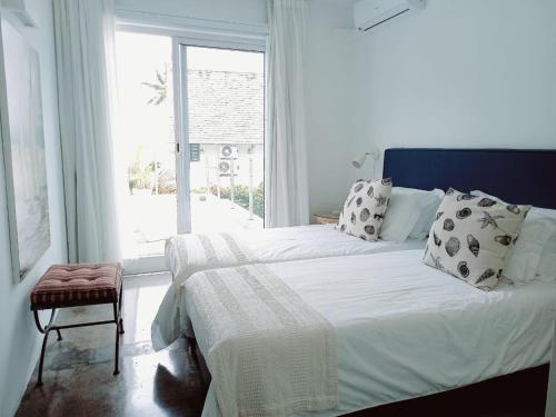 a bedroom with two beds and a window at Villa Ximun in Roches Noires