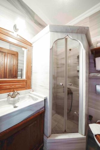 a bathroom with a shower and a sink at Cunda Tas Konak Otel in Ayvalık