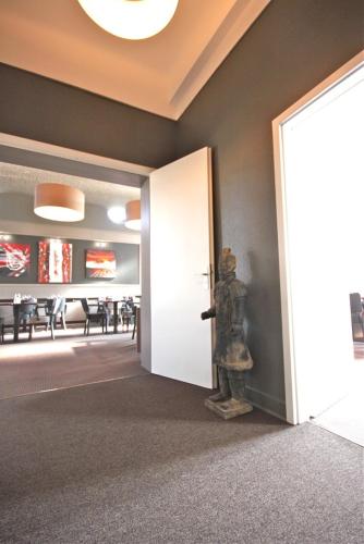 a door to a dining room with a statue of a person at Hôtel la Régie in Briey