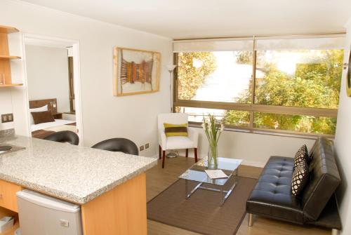 uma cozinha e sala de estar com um sofá e uma mesa em Apart Hotel Providencia em Santiago