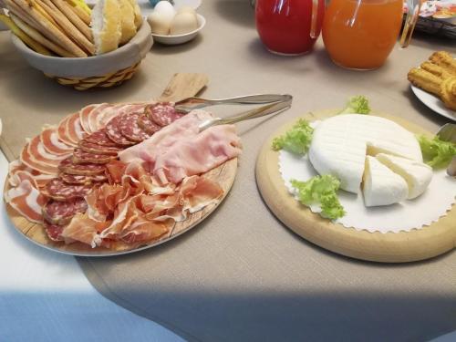 a table with a plate of food with meat and cheese at Agriturismo IL FRA' in Tigliole