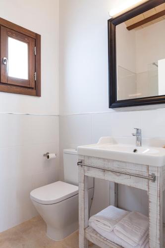 a bathroom with a sink and a toilet and a mirror at Ad Hoc Vitae Retreats & Health Only Adults in Beniarbeig