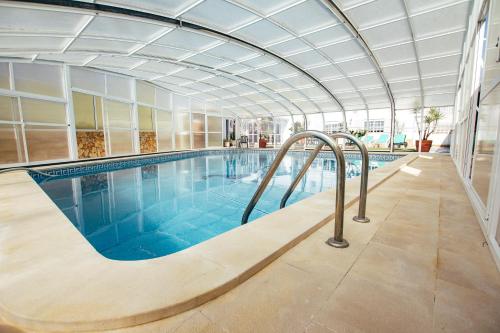 une grande piscine avec un plafond dans l'établissement Dii Beach House - Casa de Férias com piscina interior aquecida, à Torres Vedras