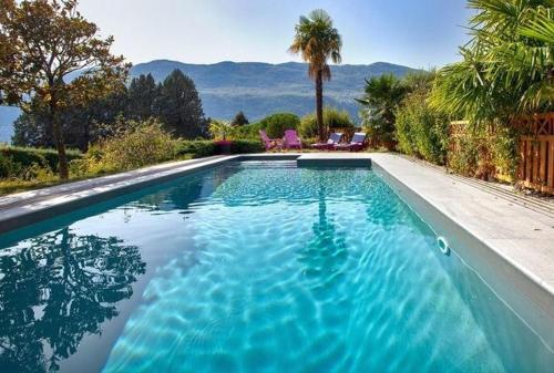 a swimming pool with blue water in a yard at Au petit Nice in Brison-Saint-Innocent