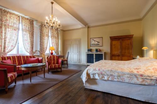 a bedroom with a bed and a table and chairs at Gästehaus Schloss Saareck in Mettlach