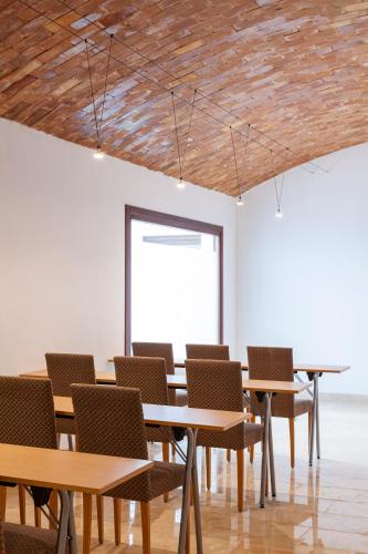 a group of tables and chairs in a room at Ad Hoc Vitae Retreats & Health Only Adults in Beniarbeig