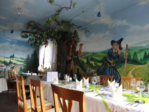 a table in a restaurant with a painting on the wall at Holzschuhs Schwarzwaldhotel in Baiersbronn