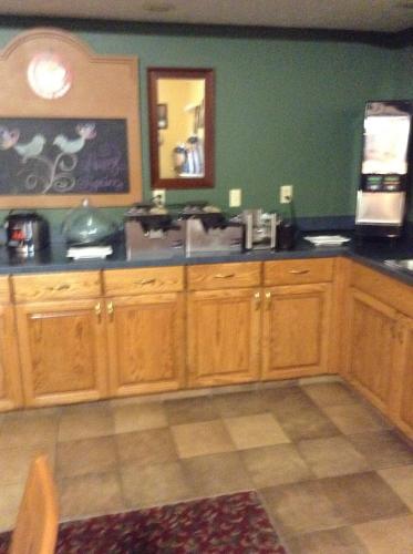 a kitchen with wooden cabinets and a sink at AmericInn by Wyndham Republic in Republic