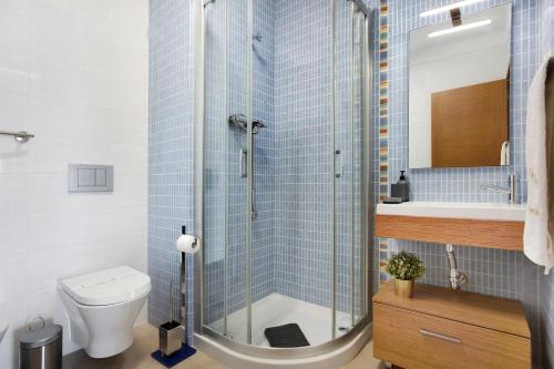een badkamer met een douche, toilet en wastafel bij Villa Rosa Apartment in Portimão