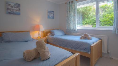 2 Einzelbetten in einem Zimmer mit Fenster in der Unterkunft Ragged Staff - 3 Bedroom Holiday Home - Saundersfoot in Saundersfoot