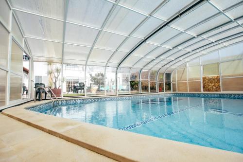 uma grande piscina com tecto em Dii Beach House - Casa de Férias com piscina interior aquecida em Torres Vedras