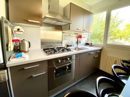 a kitchen with a stove and a sink at Saturne YourHostHelper in Caen