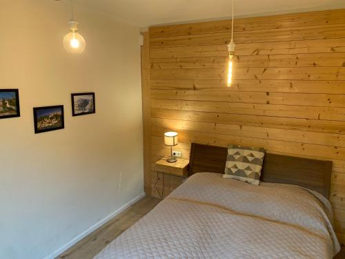 a bedroom with a bed and a wooden wall at Book-A-Room Salzburg Apartment 5-6-7-8 in Salzburg