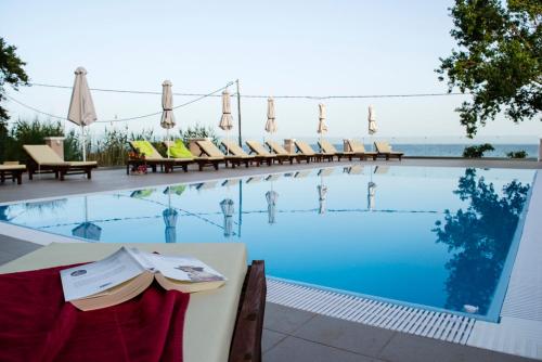 a large swimming pool with chairs and a table at Sea and Creek in Katelios