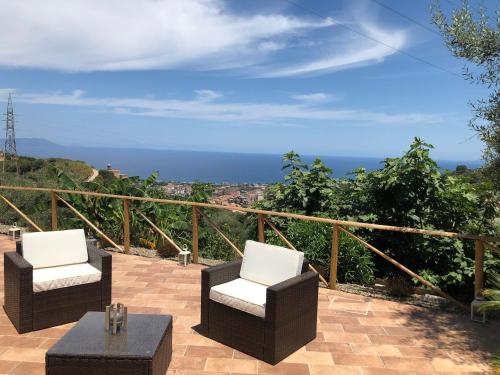 a patio with two chairs and a table and the ocean at mammaCristina in Patti