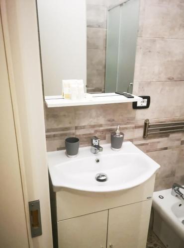 a bathroom with a white sink and a mirror at Villa Turicchio in Taranto