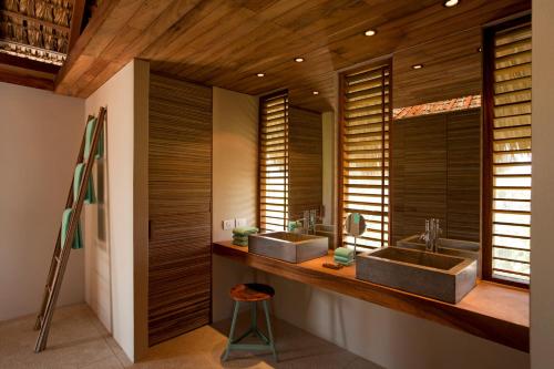 two sinks in a bathroom with wooden walls at Hotel Escondido, Puerto Escondido, a Member of Design Hotels - Adults Only in Puerto Escondido