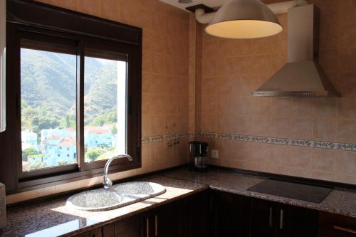 eine Küche mit einem Waschbecken und einem Fenster darin in der Unterkunft Casa el Genal in Júzcar