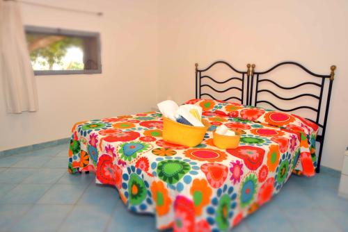 a colorful bed with two baskets on top of it at I Dammusi Sapori di Pantelleria in Pantelleria
