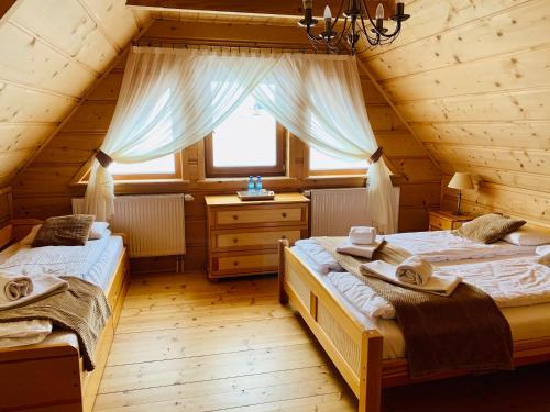 a bedroom with two beds in a log cabin at Dom Pod Bachledówką in Czerwienne