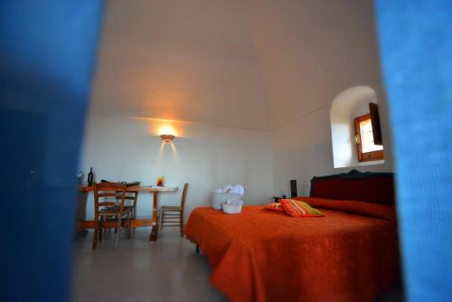 a bedroom with a bed and a table and a dining room at I Dammusi Sapori di Pantelleria in Pantelleria