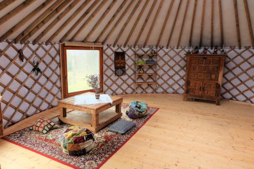 an interior of a yurt with a table and a rug at Jurtos nuoma in Kartena