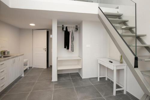 a room with a staircase and a hallway with a closet at El Greco Studios in Agia Marina Nea Kydonias