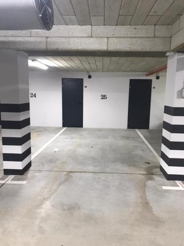 an empty parking lot with three doors in a parking garage at Apartament Kamila Ostróda in Ostróda