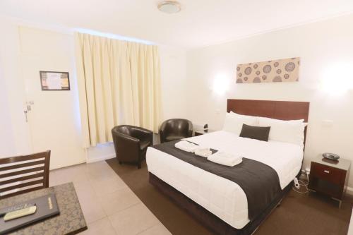 a hotel room with a bed and a desk at The Esplanade Motel in Lakes Entrance