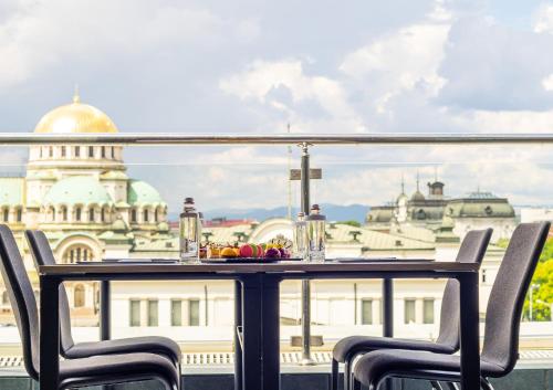 a table on a balcony with a view of a building at InterContinental Sofia, an IHG Hotel in Sofia