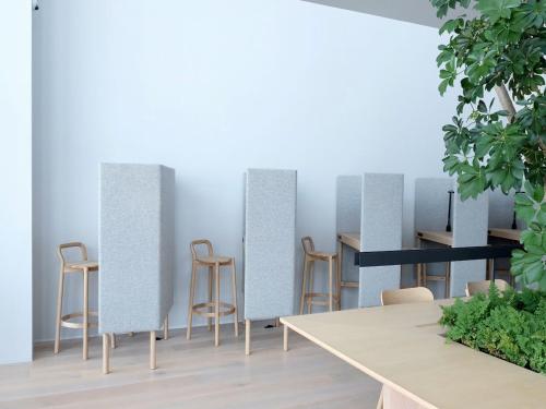 a room with chairs and tables and a wall of mirrors at 9h nine hours Hakata station in Fukuoka