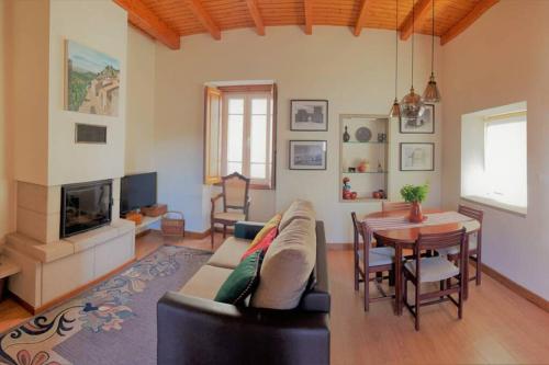 a living room with a couch and a table at Casa de Sampaio - Castelo Mendo in Castelo Mendo