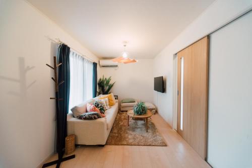 Yamada的住宿－Plage，带沙发和窗户的客厅