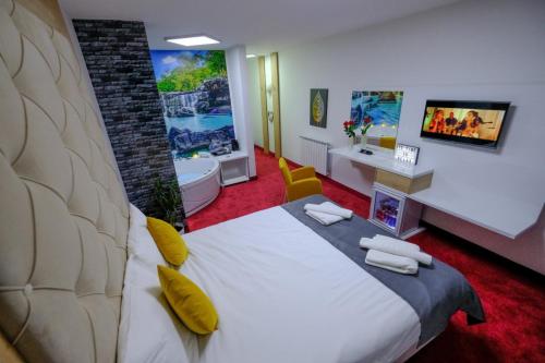 um quarto de hotel com uma cama grande e uma casa de banho em Delux Apartmani Bulevar em Saraievo